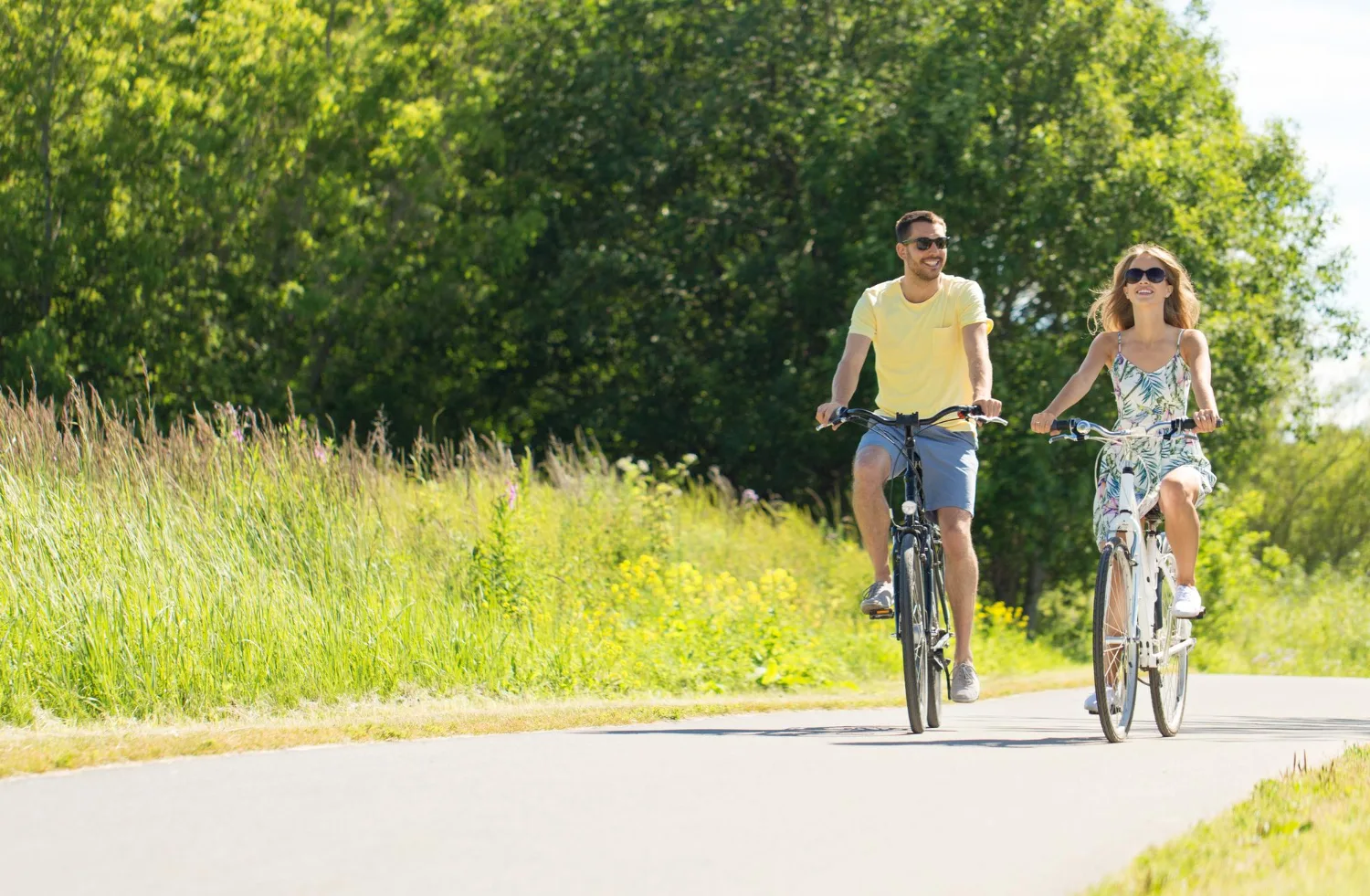 Un jeune couple heureux à vélo en été.