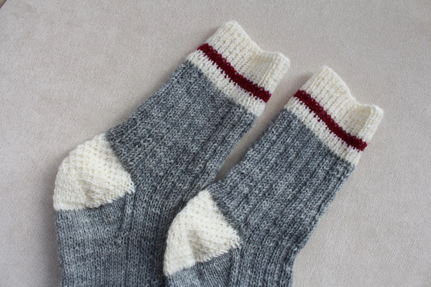 Une paire de chaussettes grises et blanches posée au sol